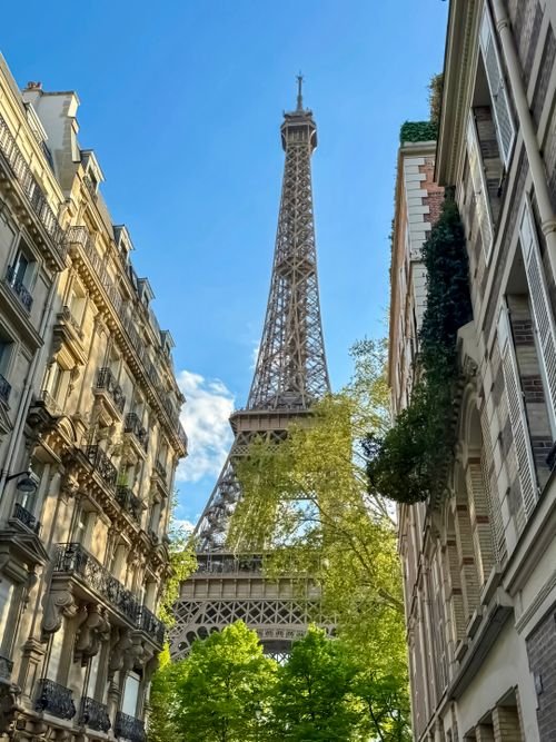 The Eiffel Tower between classic Parisian apartment buildings